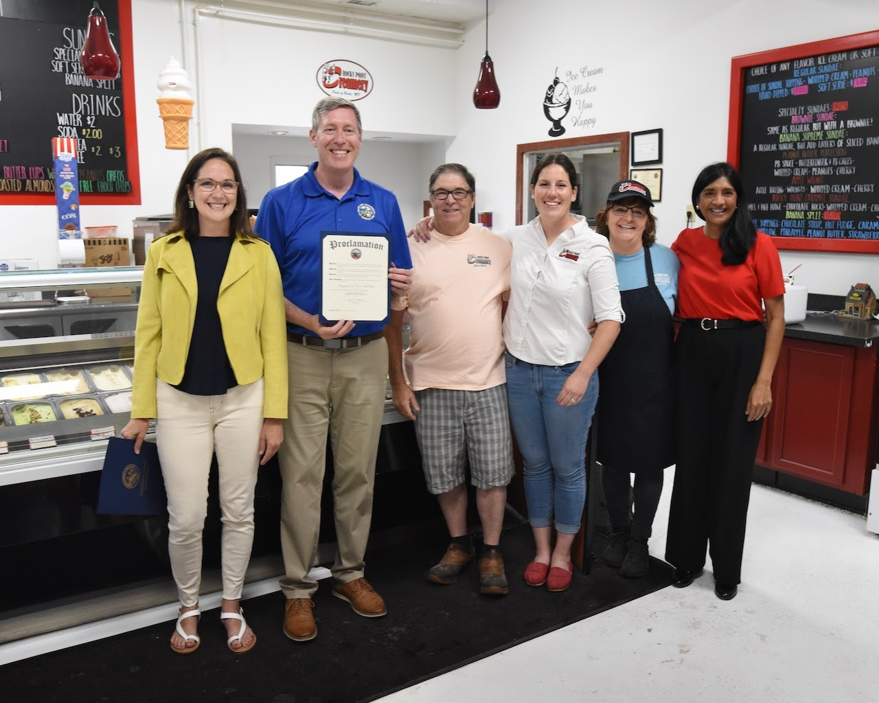 Aruna Miller and Kevin Atticks standing with Creamery owners before getting ice cream