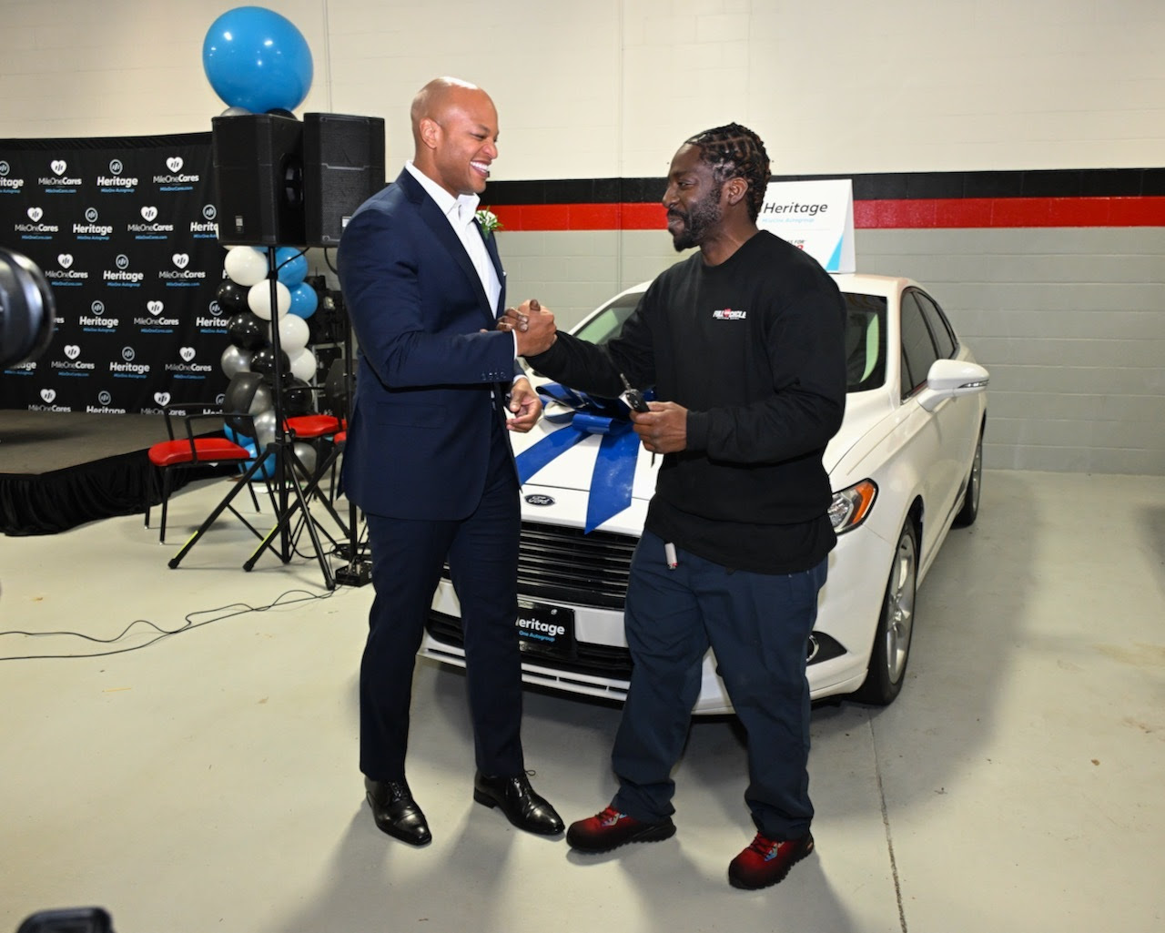 Governor Moore celebrates a new vehicle given to a Maryland veteran at the Owings Mills Vehicles for Change event.