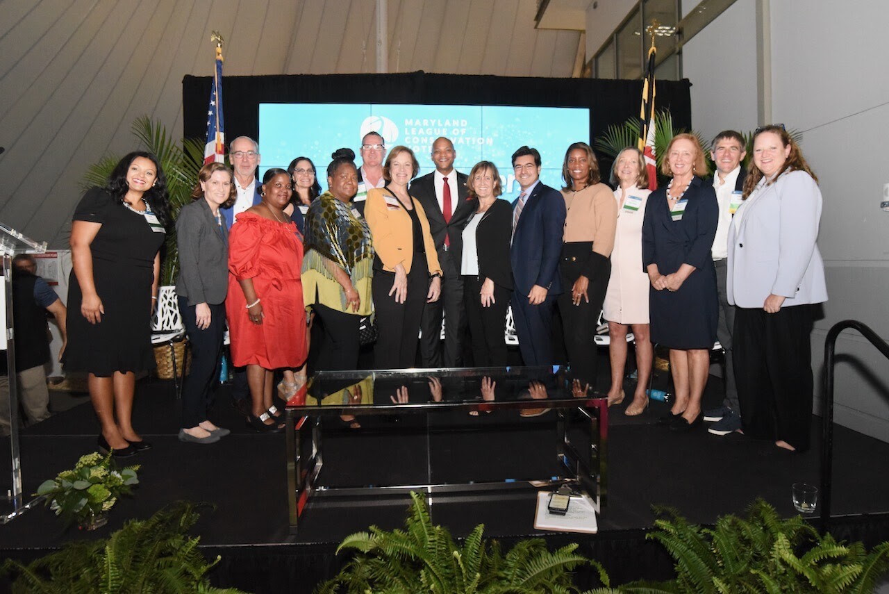 Governor Moore stands with crowd onstage at the 2023 Maryland League of Conservation Voters Changemakers event.